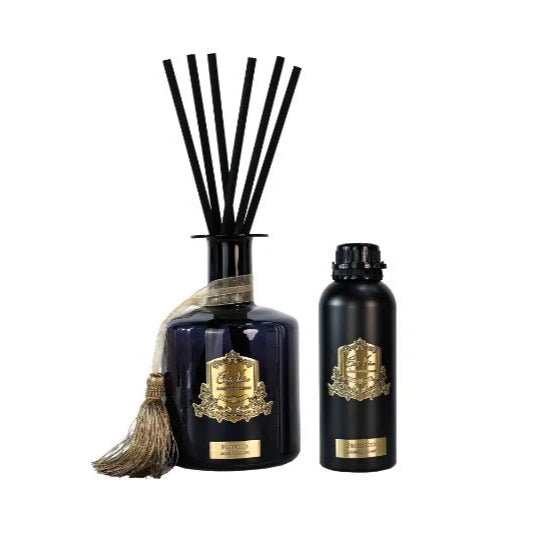 Two black diffusers with gold accents on a white background