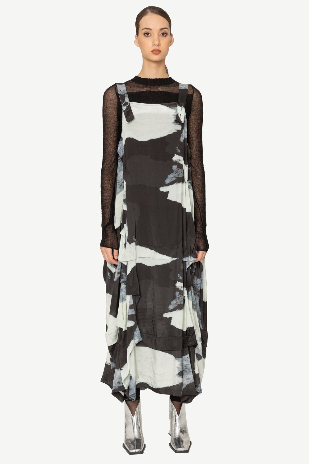 Model wearing a black and white patterned dress on a white background