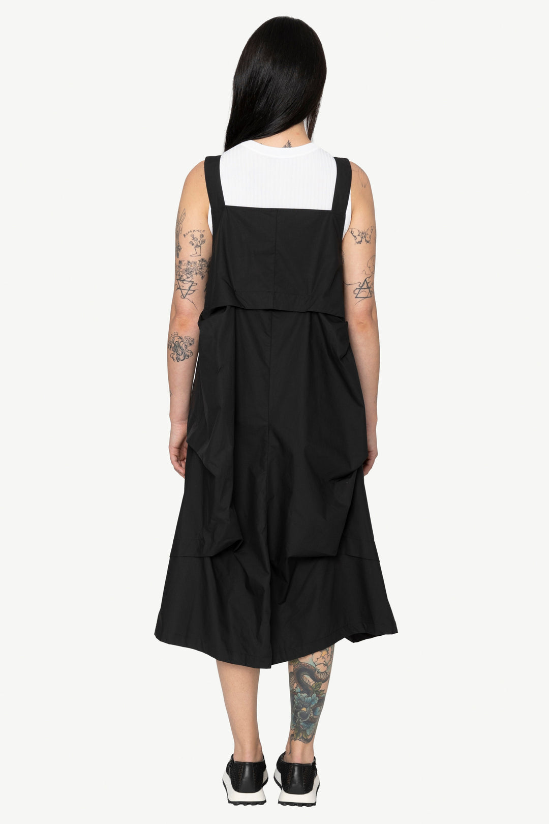 Person wearing a black dress with a white top on a white background