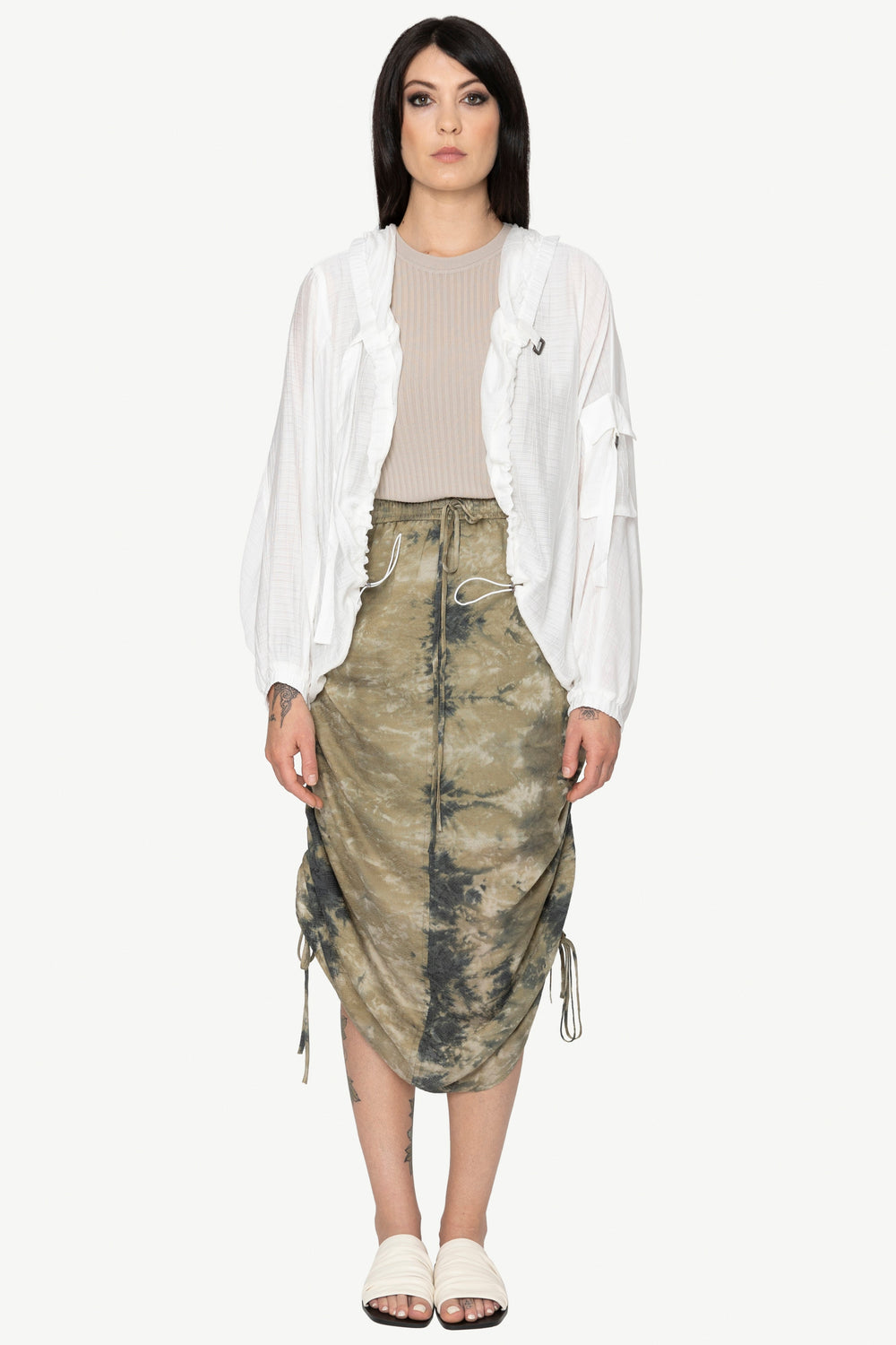 Woman wearing a white shirt and camouflage skirt on a white background