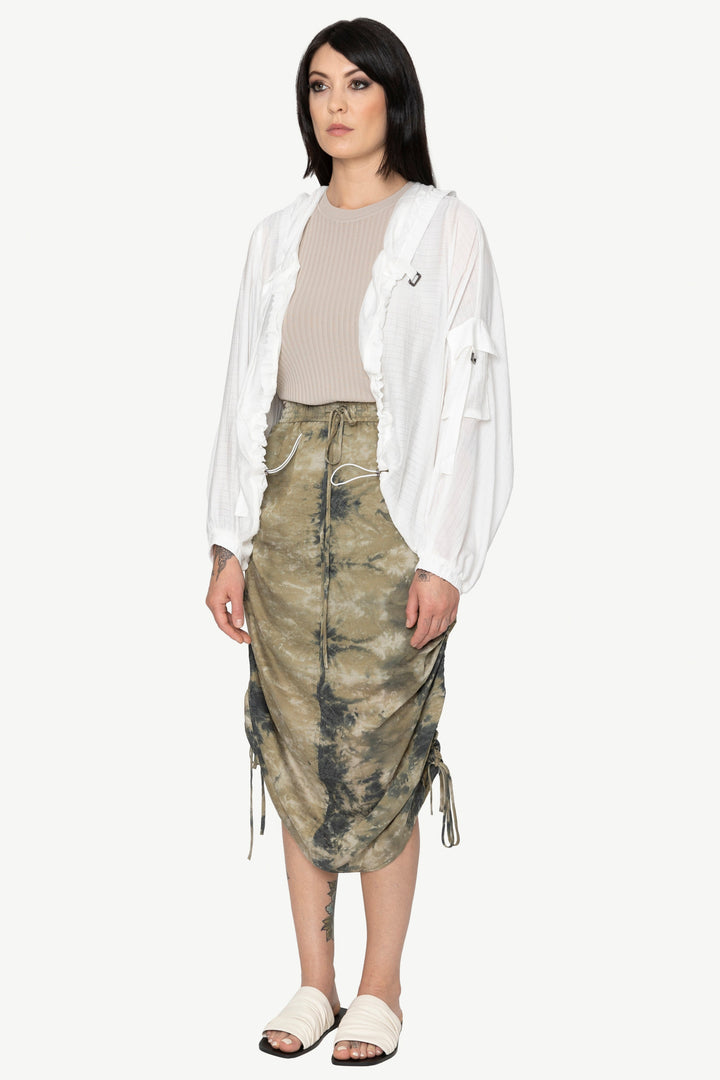 Woman wearing a white shirt and camouflage skirt on a white background