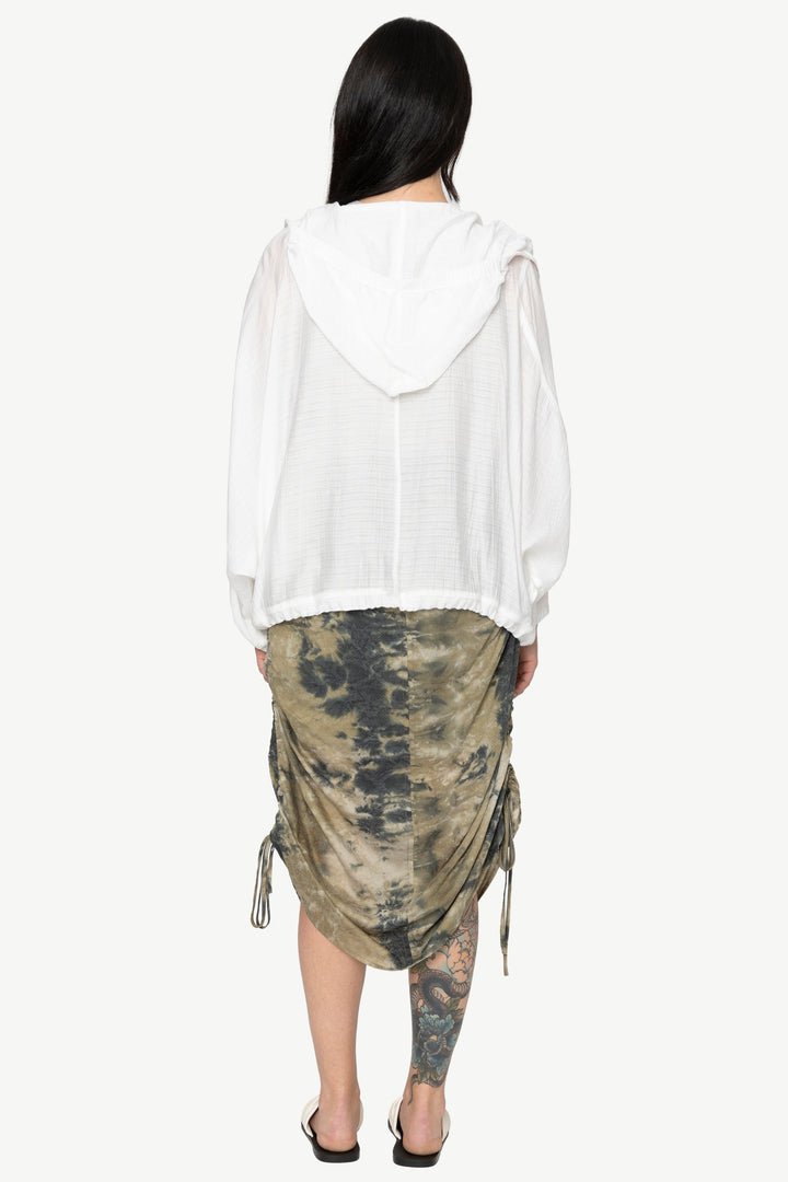 Person wearing a white blouse and camouflage skirt on a white background