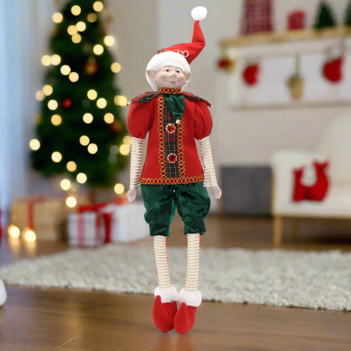 Christmas elf doll in red and green outfit on a white background