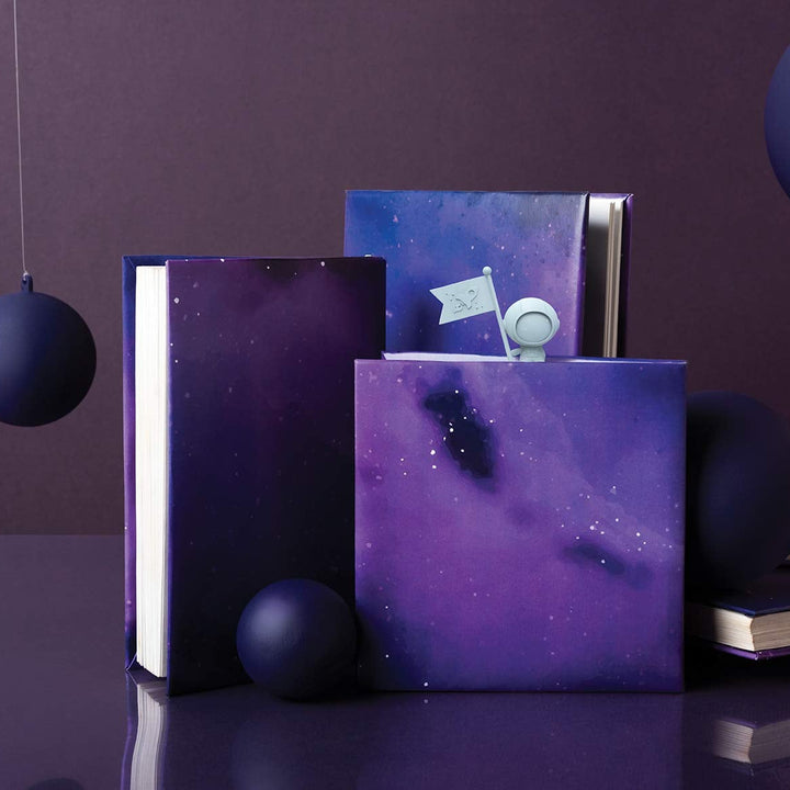 Purple galaxy-themed books with decorative spheres on a dark background