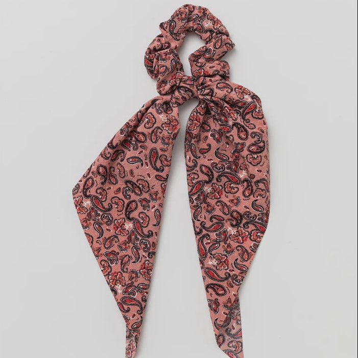 Pink paisley patterned scarf on a light gray background