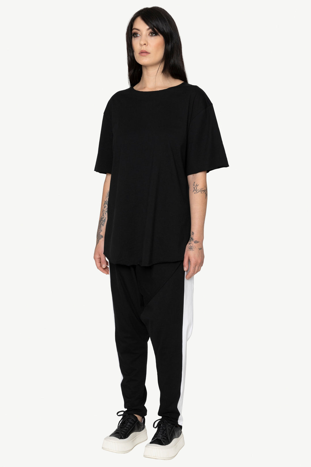 Person wearing a black outfit with a white stripe on a white background