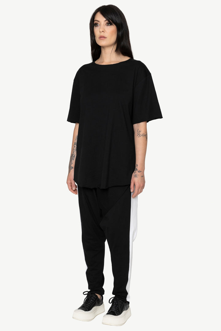 Person wearing a black outfit with a white stripe on a white background
