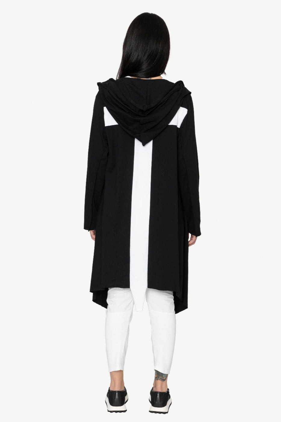Person wearing a black hooded coat on a white background