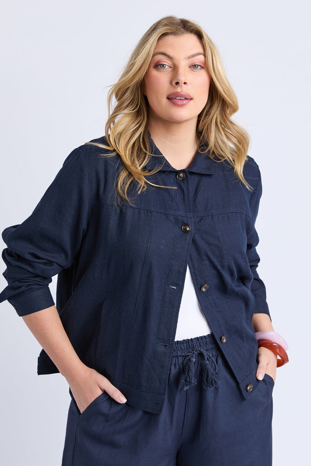 Woman wearing a navy blue outfit with a white background
