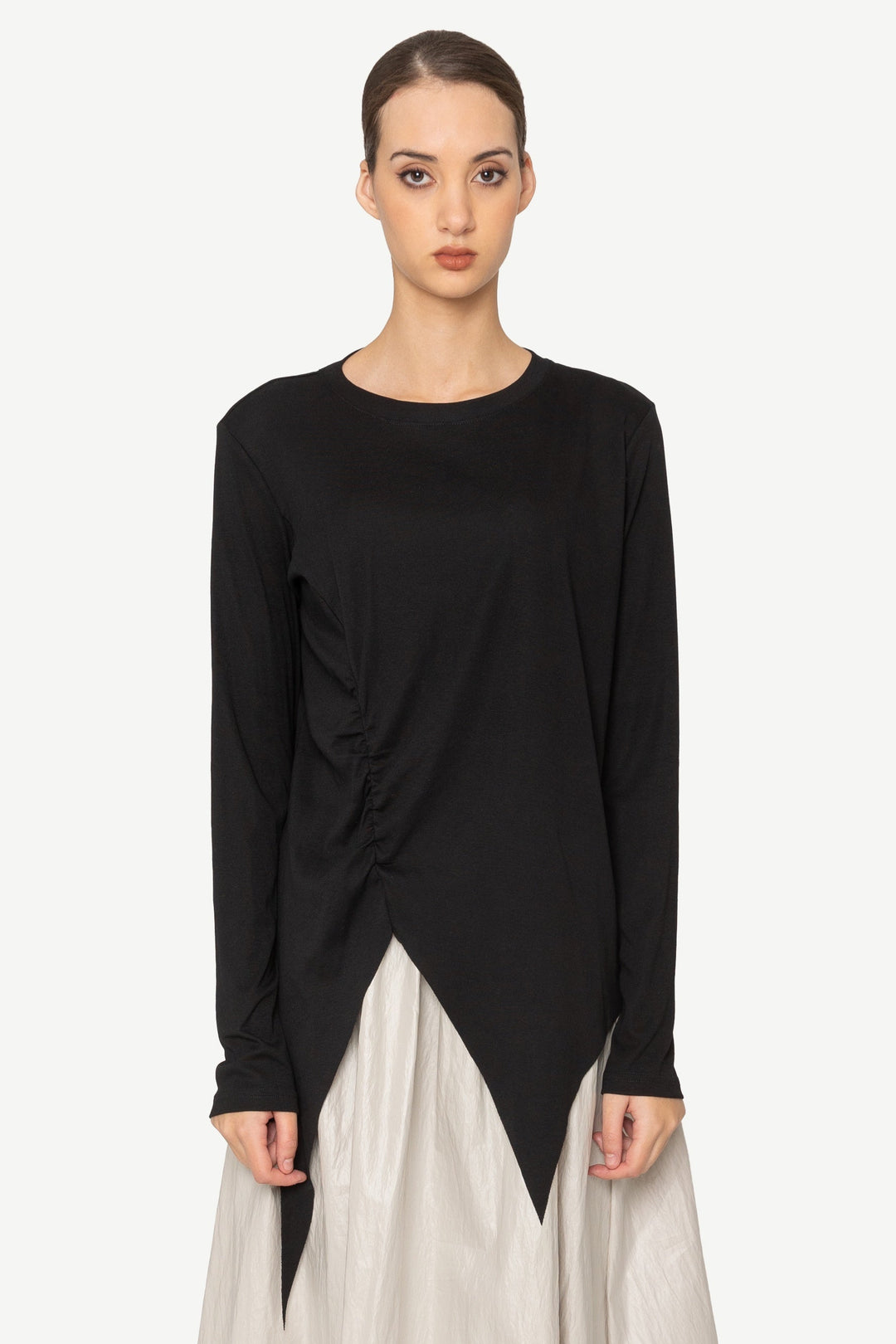 Woman wearing a black top and beige skirt on a white background