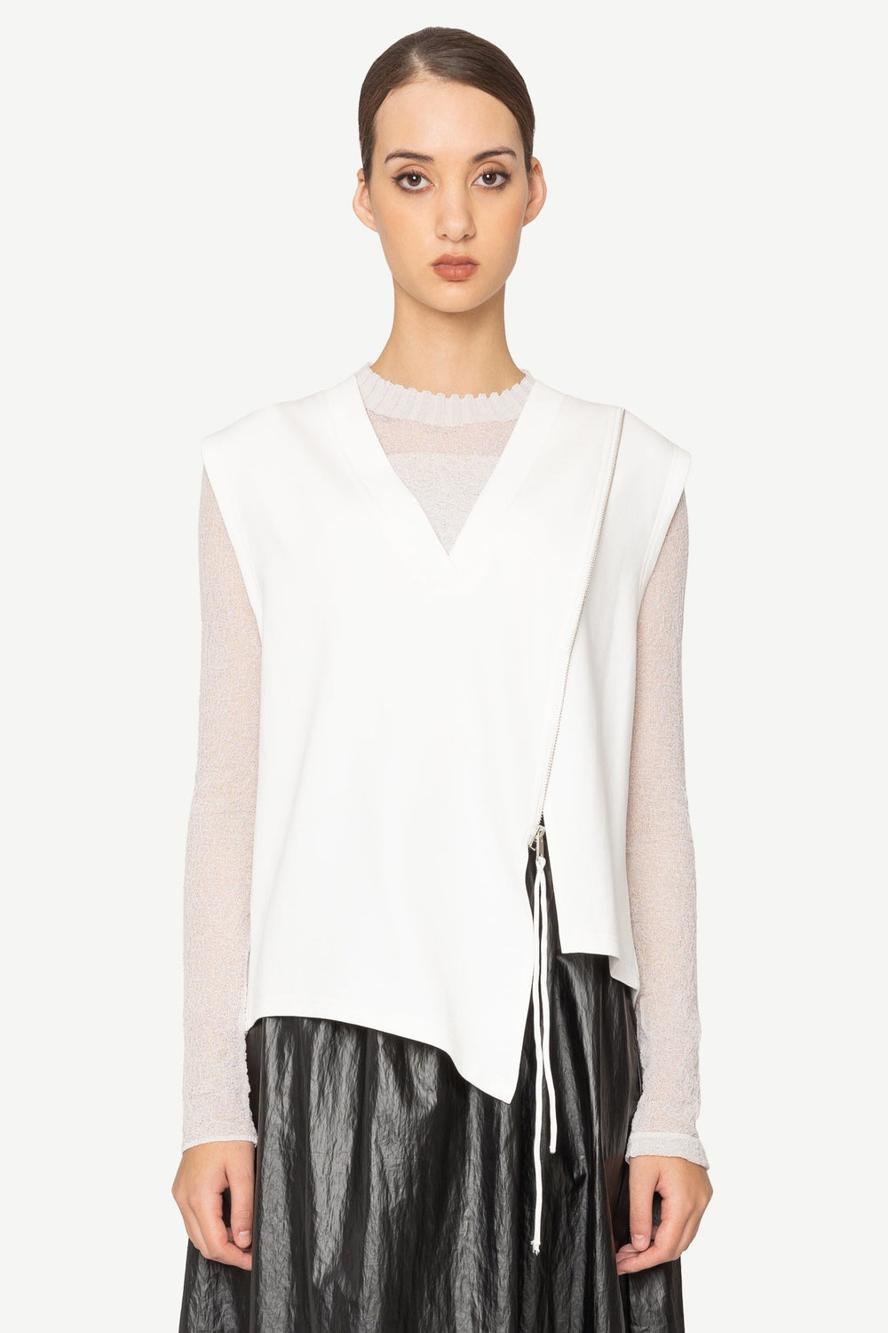 Woman wearing a white blouse and black leather skirt on a white background
