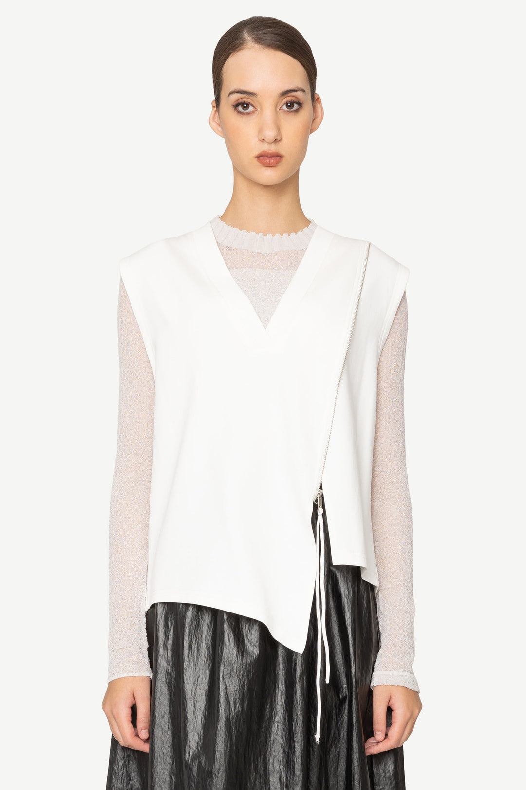 Woman wearing a white blouse and black leather skirt on a white background