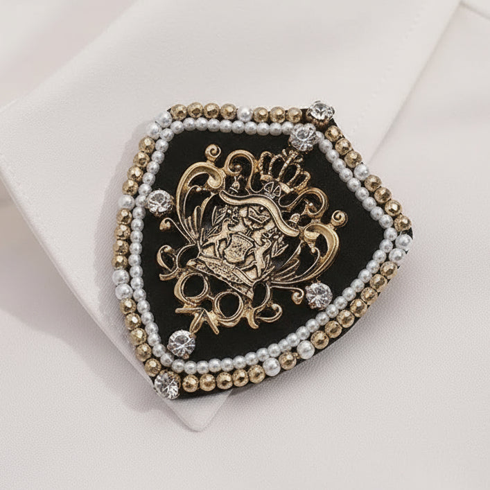 Decorative brooch with intricate design and beaded border on a beige background
