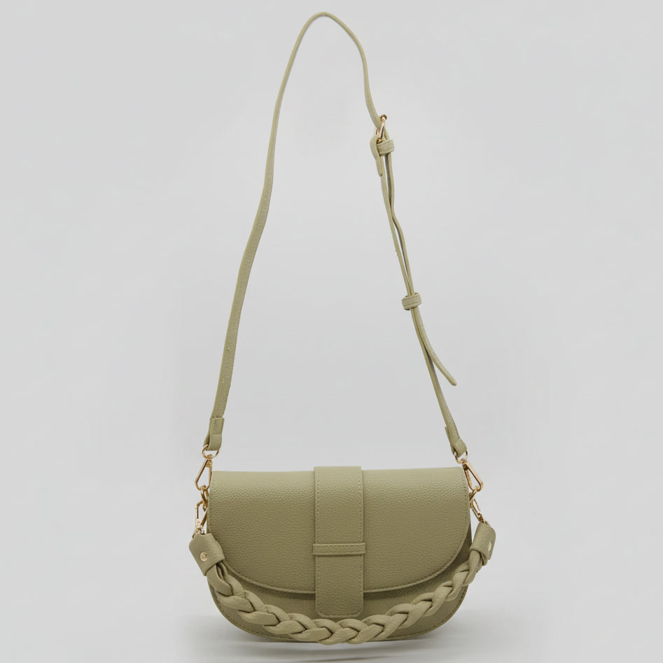 Green handbag with braided detail on a light gray background