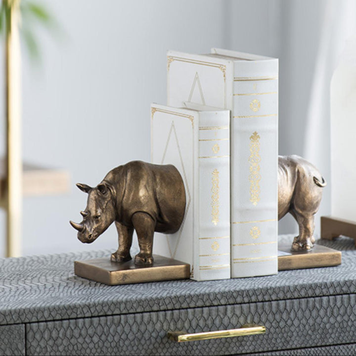 Bronze rhino bookends on a surface with a neutral background