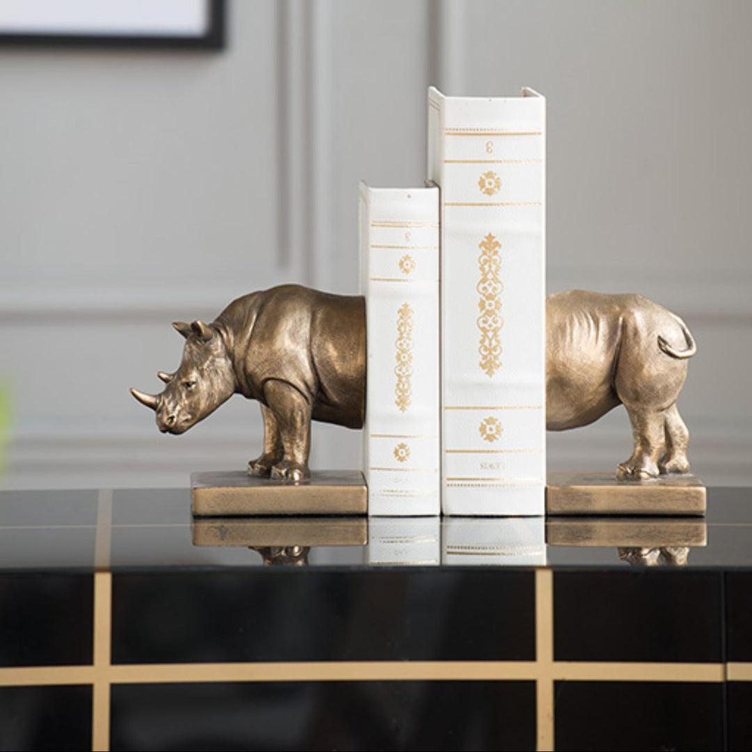 Decorative bookends shaped like rhinos on a shelf with a neutral background