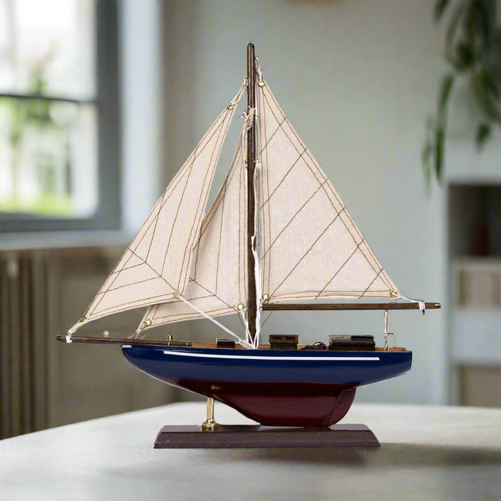 Model sailboat with white sails on a white background