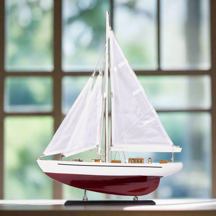 Model sailboat with white sails on a white background