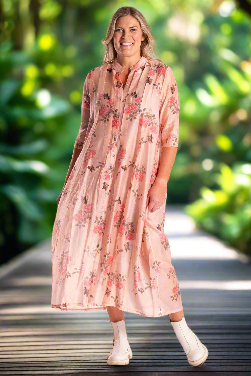 Woman wearing a pink floral dress on a white background