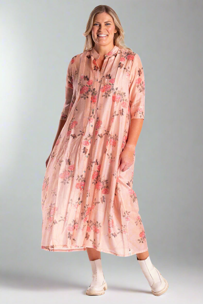 Woman wearing a pink floral dress on a white background