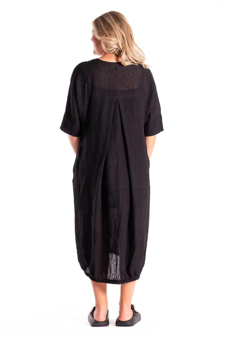 Woman wearing a black dress with sheer panels on a white background