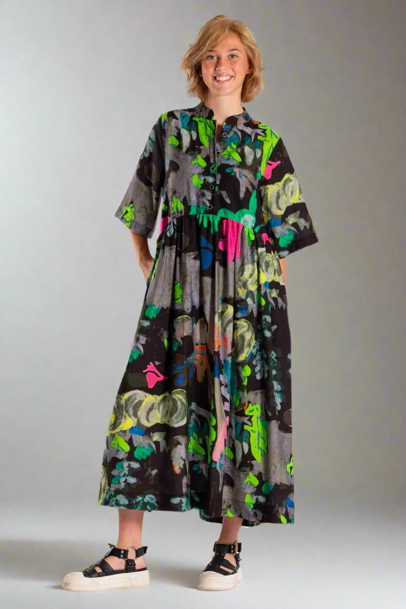 Woman wearing a colorful dress with abstract patterns on a white background