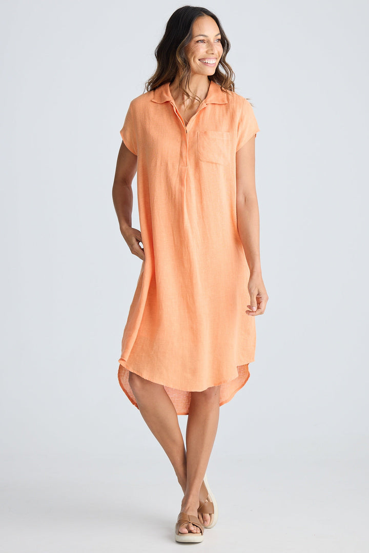 Woman wearing a peach sleeveless dress on a white background