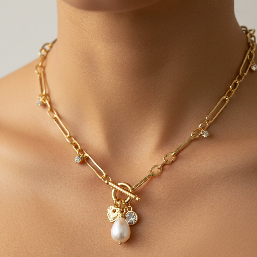 Gold necklace with a pearl pendant on a mannequin bust against a white background