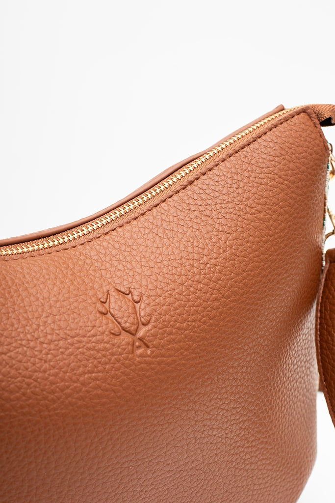 Brown leather handbag with a visible brand logo on a white background