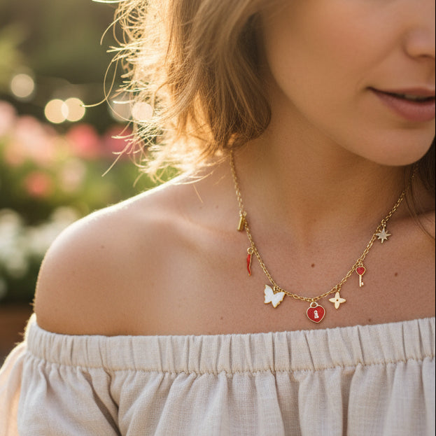 Gold necklace with various charms on a white background