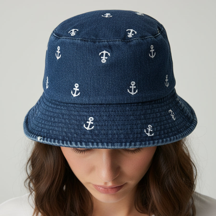 Blue bucket hat with white anchor patterns on a light gray background
