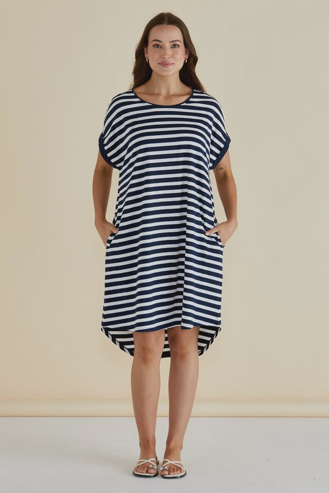 Woman wearing a betty basics black and white striped dress against a beige background, available in regular & plus sizes