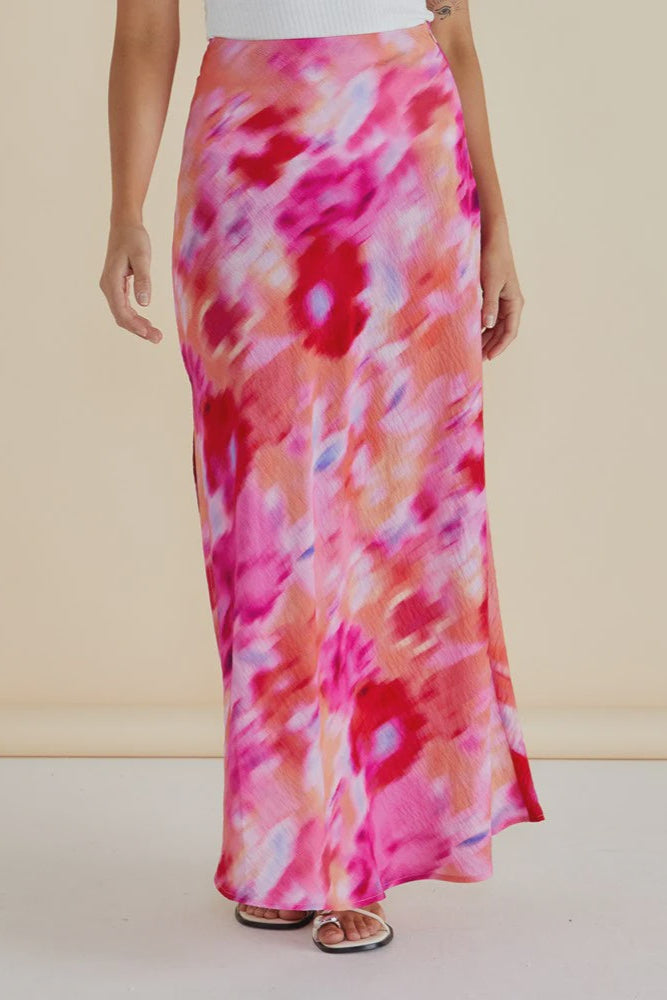 Person wearing a pink floral betty basics bias skirt on a plain background