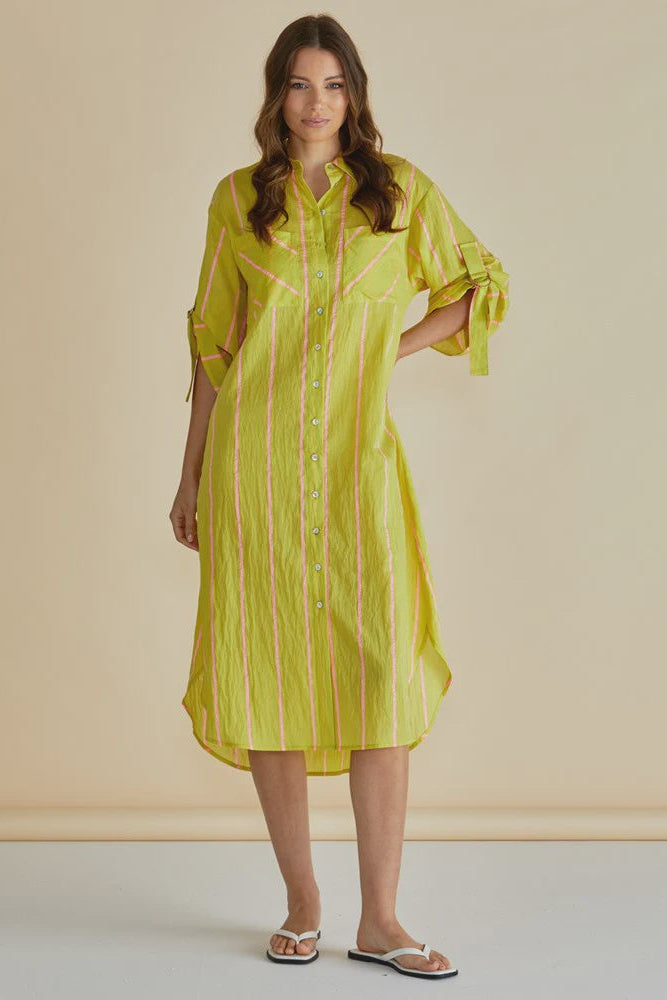 Woman wearing a yellow striped dress against a beige background