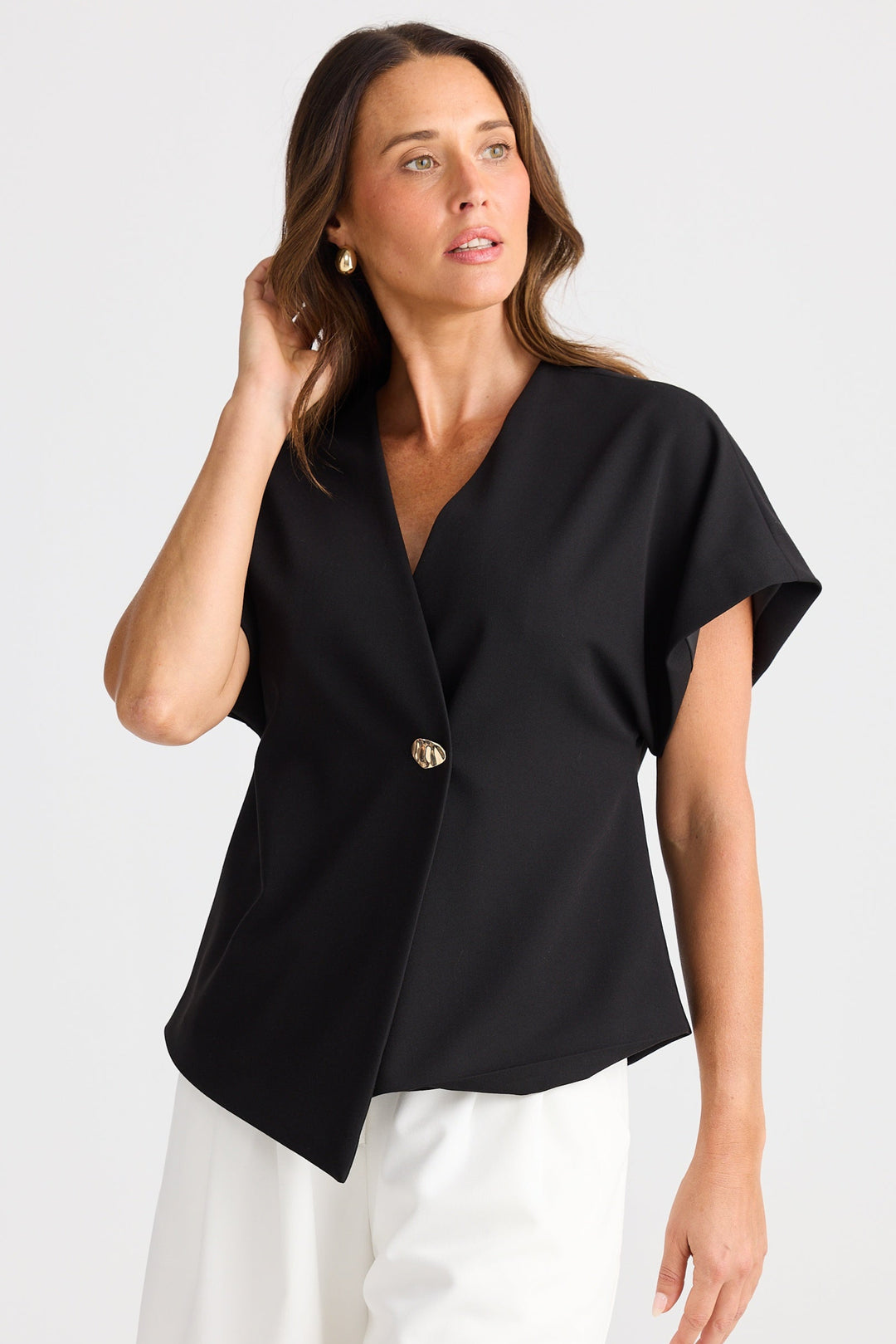 Woman wearing a black top and white shorts on a white background