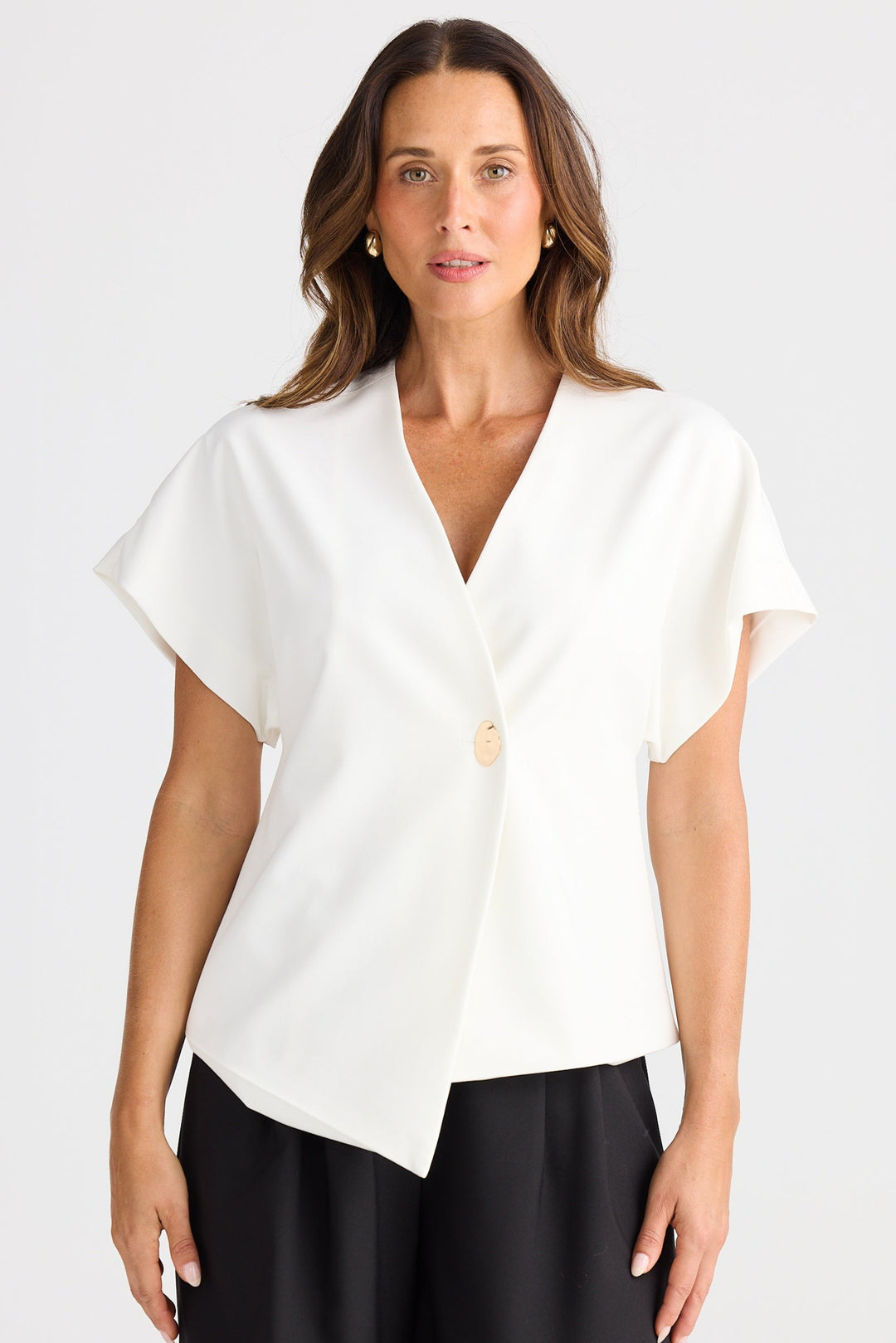 Woman wearing a white blouse with a V-neck and black shorts on a white background
