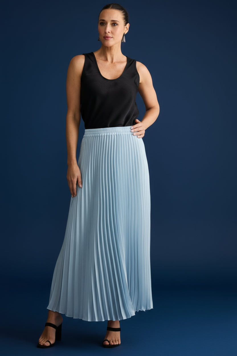 Woman wearing a black sleeveless top and light blue pleated skirt on a white background