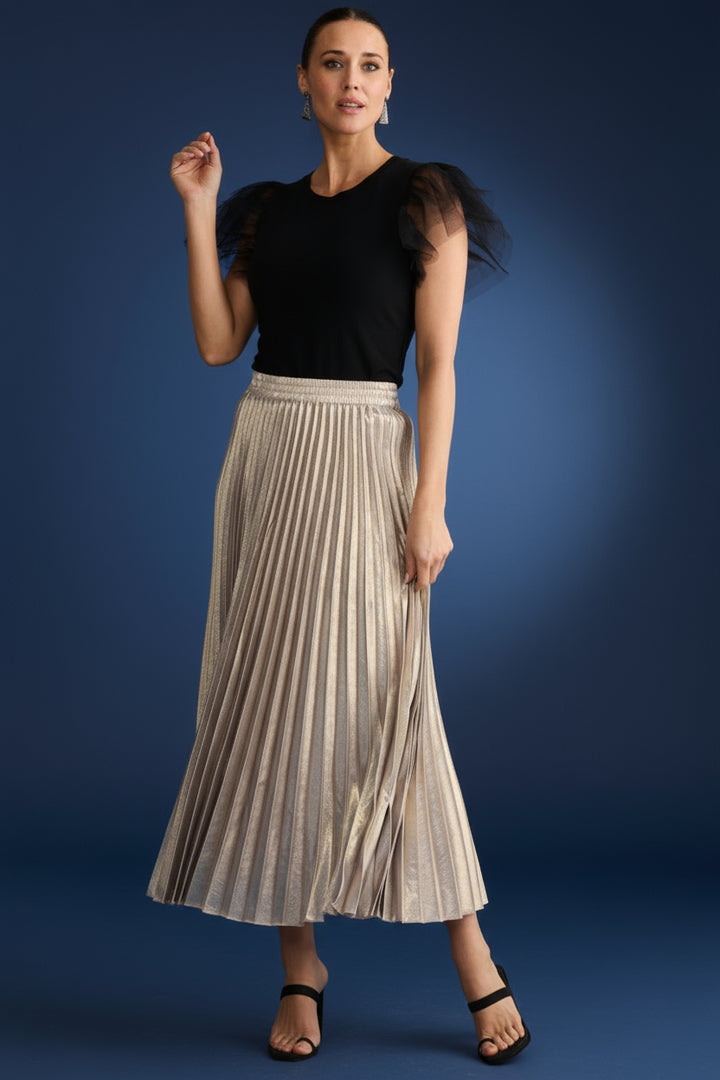 Woman wearing a black top and pleated metallic brave & true alias skirt on a white background