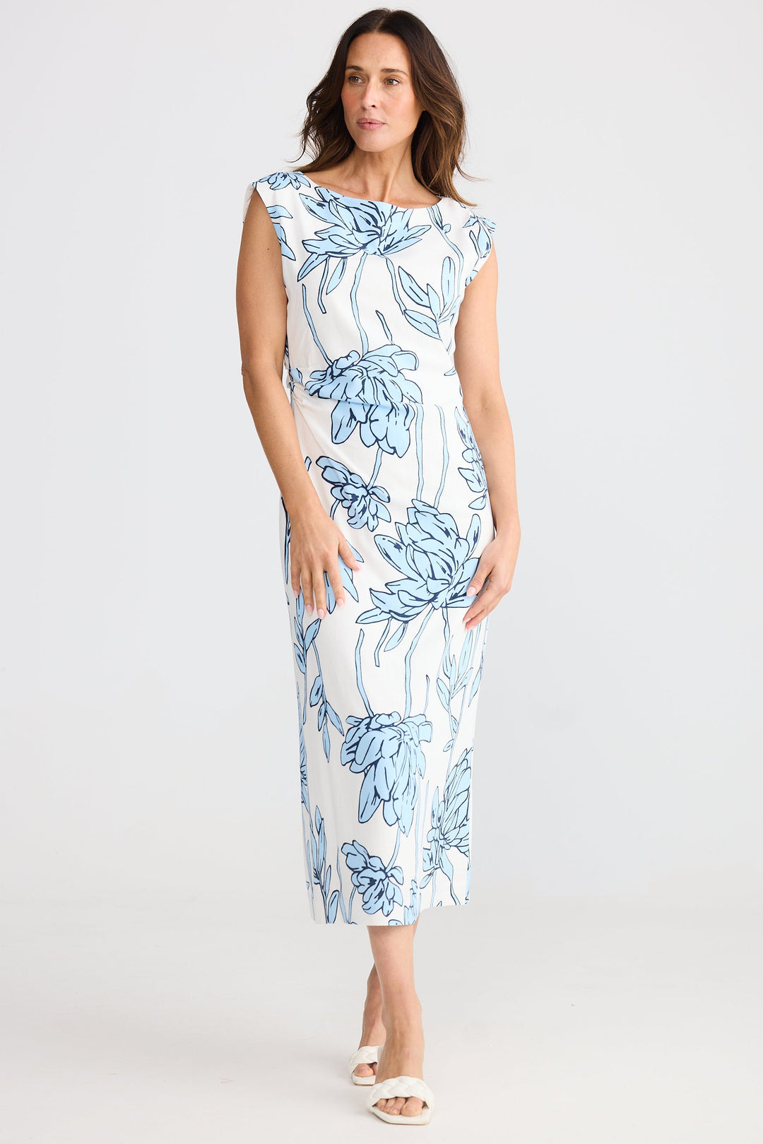 Woman wearing a white dress with blue floral pattern on a white background
