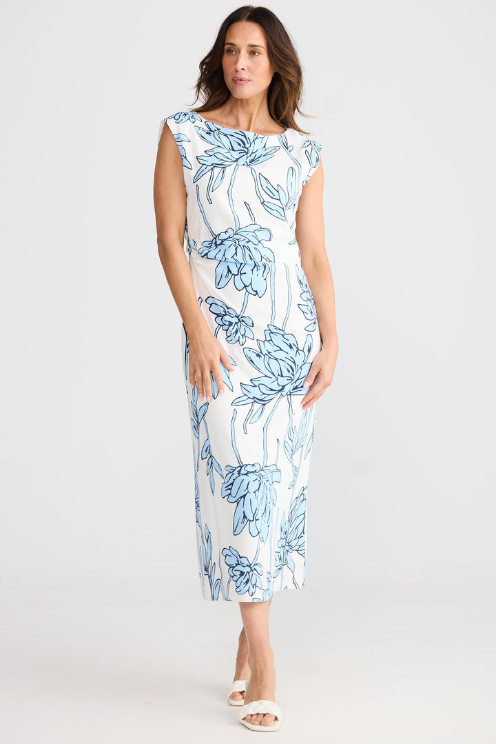 Woman wearing a white dress with blue floral pattern on a white background