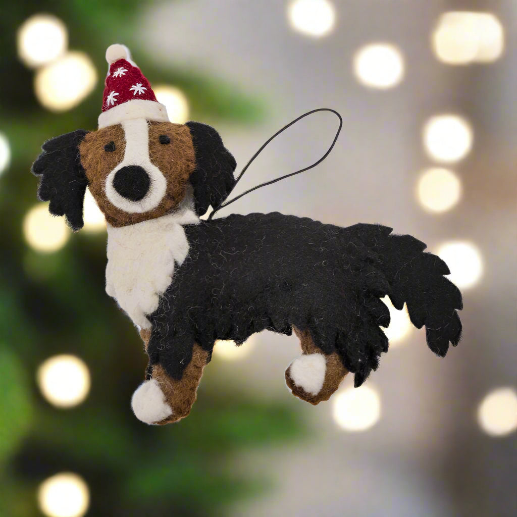 Dog-shaped Christmas ornament with a Santa hat on a white background