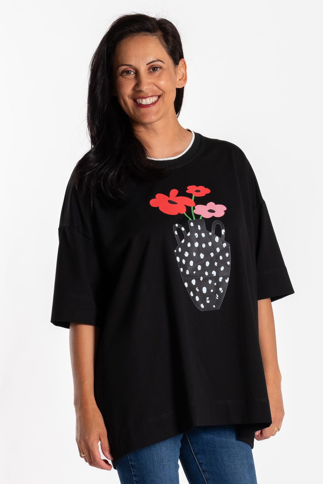 Woman wearing a black jellicoe t-shirt with a graphic design on a white background