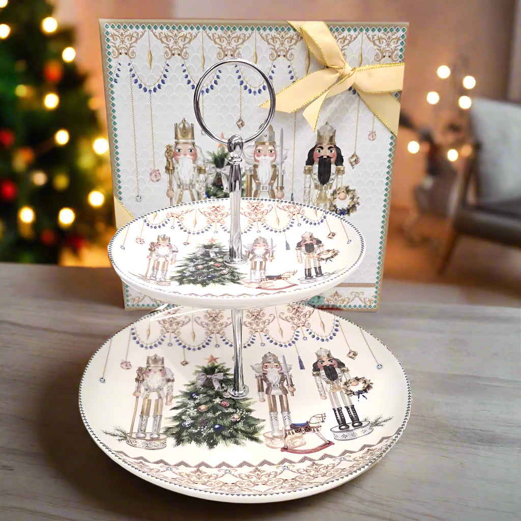 Two decorative plates with nutcracker design on a stand, featuring a gift box with a yellow ribbon in the background.