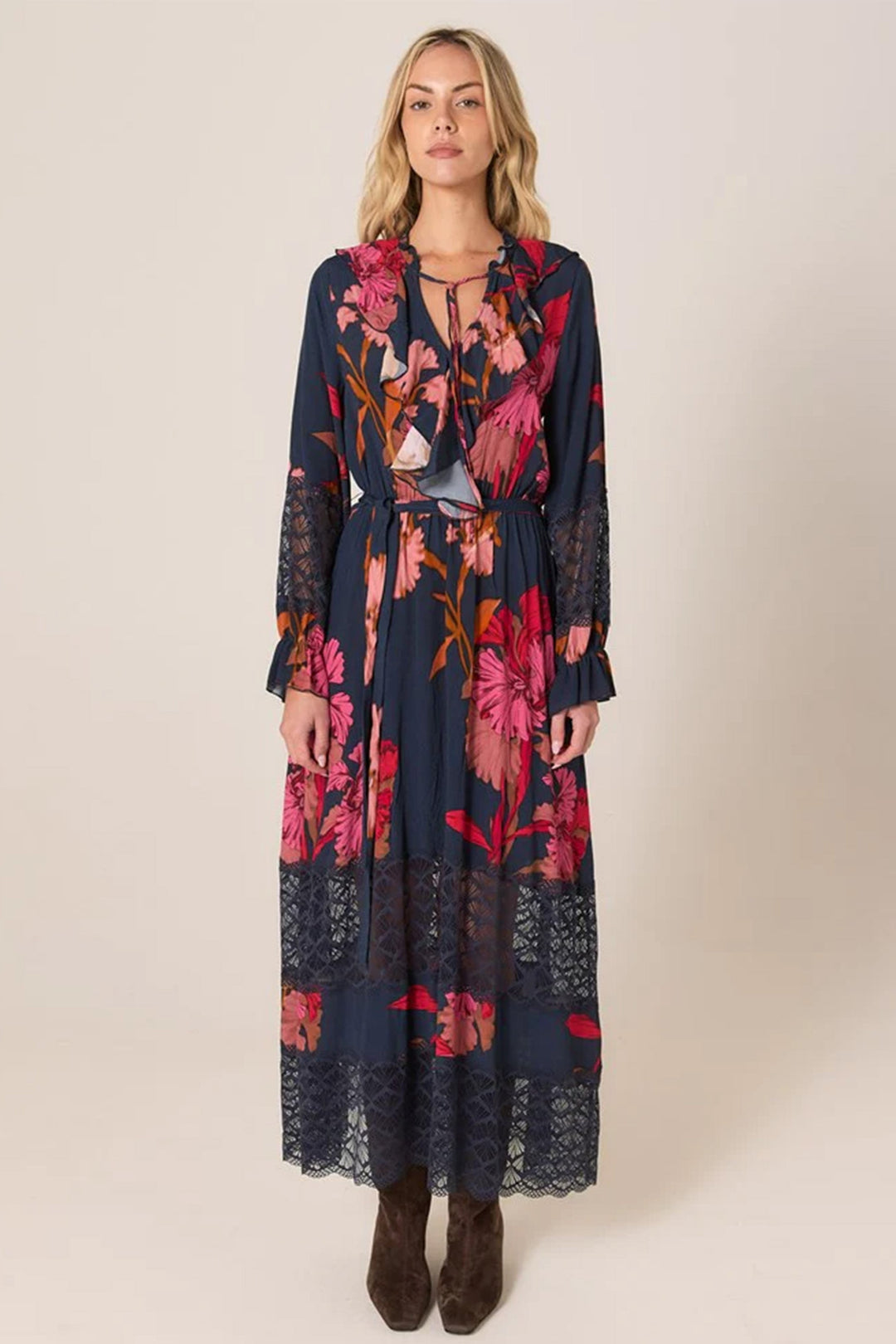 Woman wearing a long floral dress with a plain background