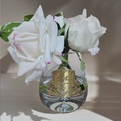Decorative vase with flowers and a gold emblem on a neutral background