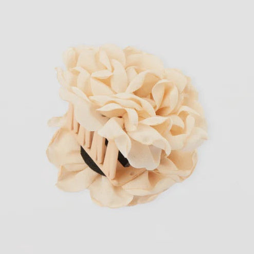 Beige hair clip with floral design on a light gray background