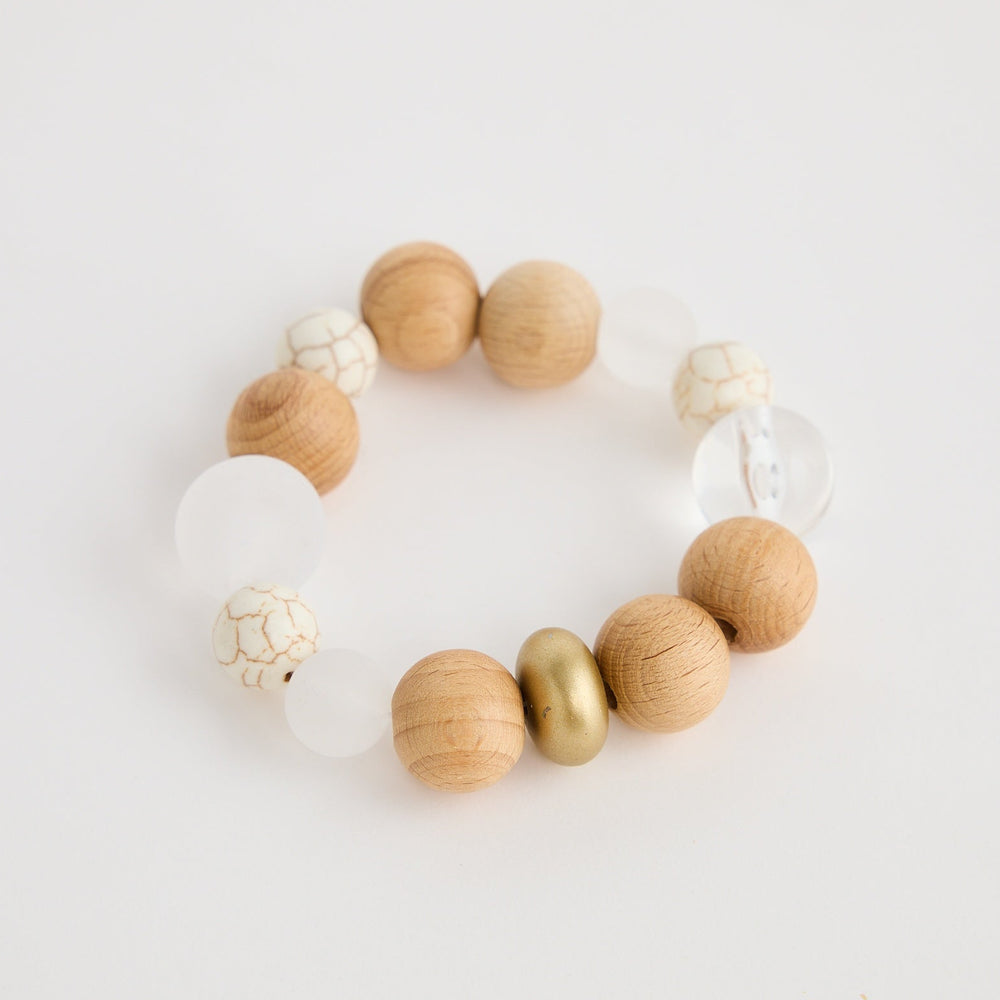 Bracelet with wooden and gold beads on a light background