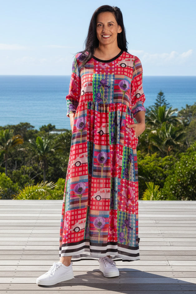 Woman wearing a colorful patterned JELLICOE dress on a white background