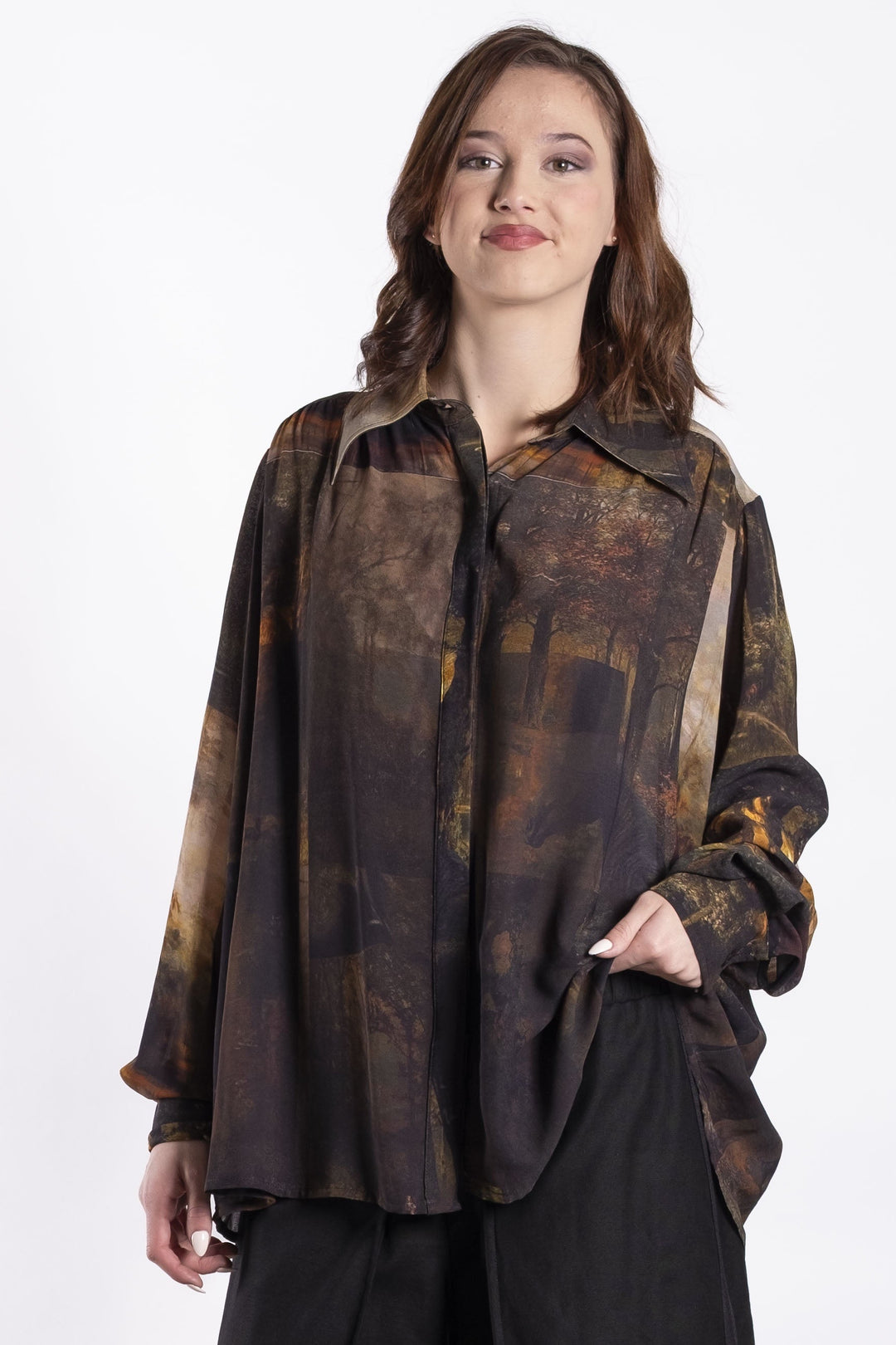 Woman wearing a patterned Deeanne Hobbs shirt and black pants on a white background