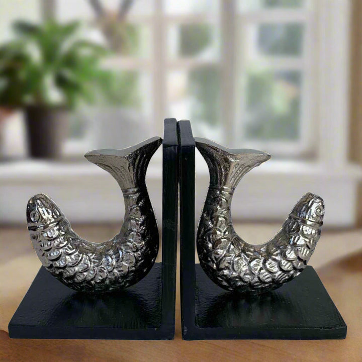Pair of decorative bookends with fish design on a white background